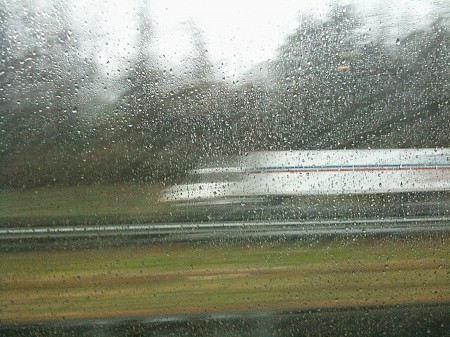 Mail truck through window in the rain.