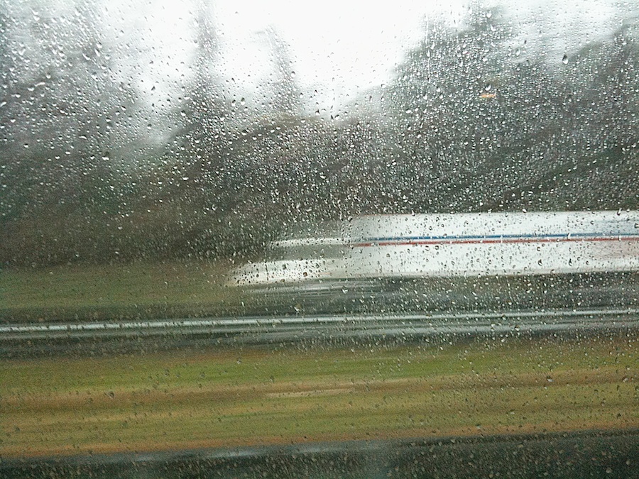 Mail truck through window in the rain.