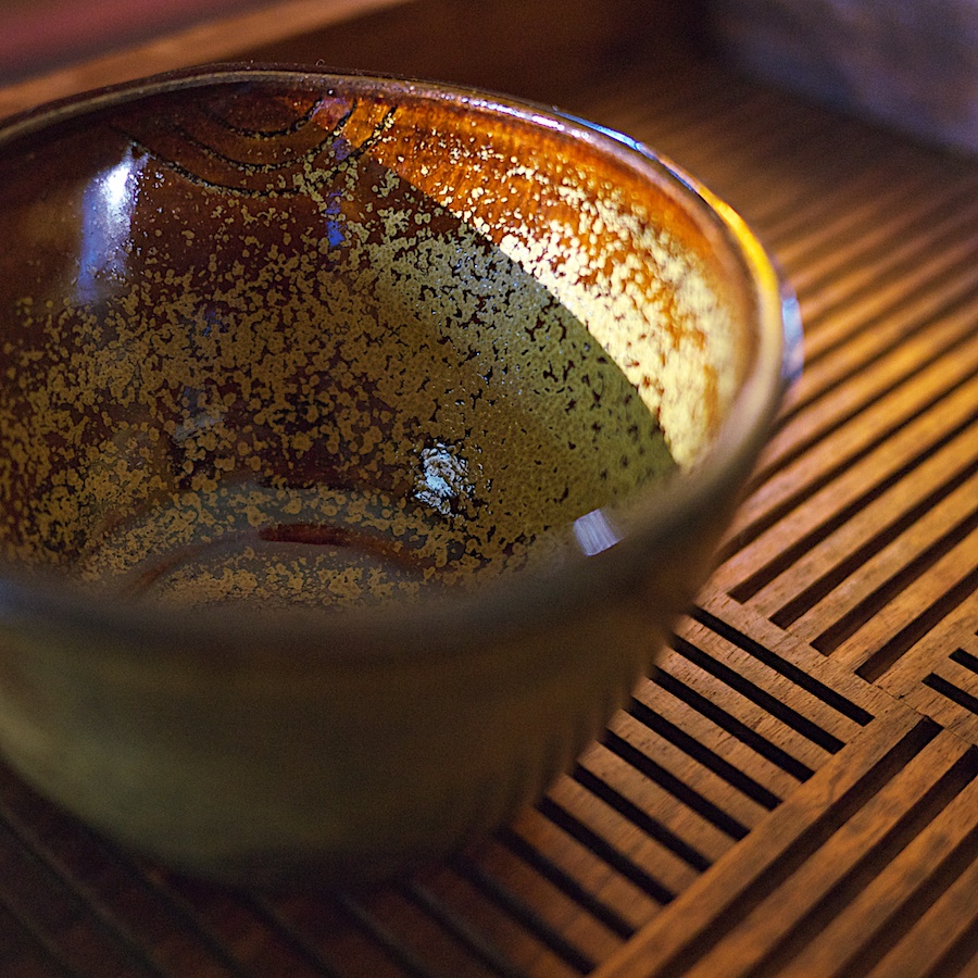 Ceramic cup on wooden tray.