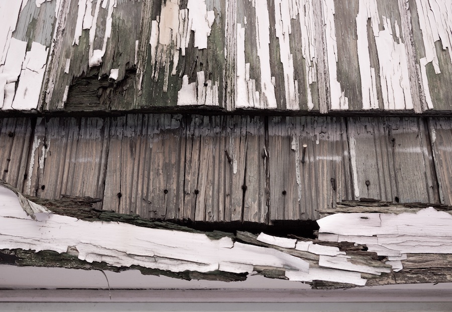 Peeling paint & exposed wood.