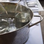Glass water bottles in a metal pan.