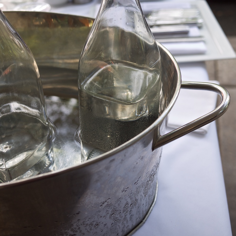 Glass water bottles in a metal pan.