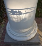 Lawn furniture casts a shadow on a pillar.