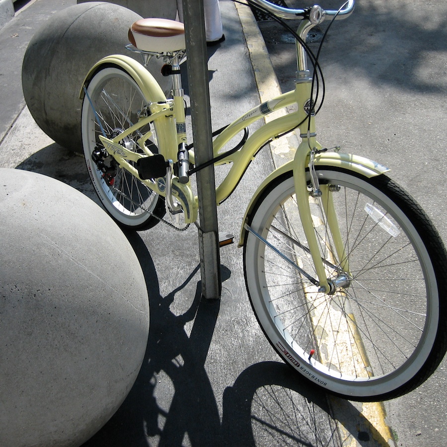 Yellow bicycle by round bollards.