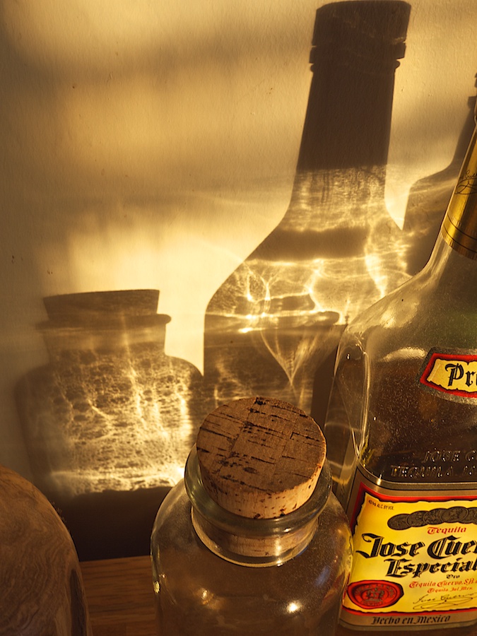 Late afternoon light refracted through glass bottles.