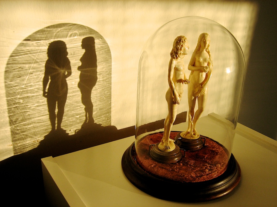 Ivory sculptures of Adam & Eve in a bell jar.