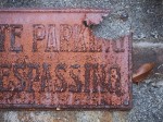 Rusted no trespassing sign.