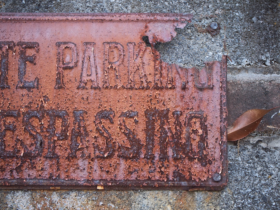 Rusted no trespassing sign.