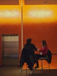 Couple in silhouette at table.