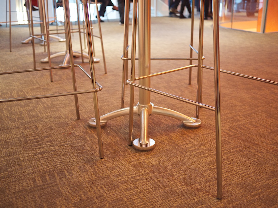 Table and chair legs, people's feet in background.