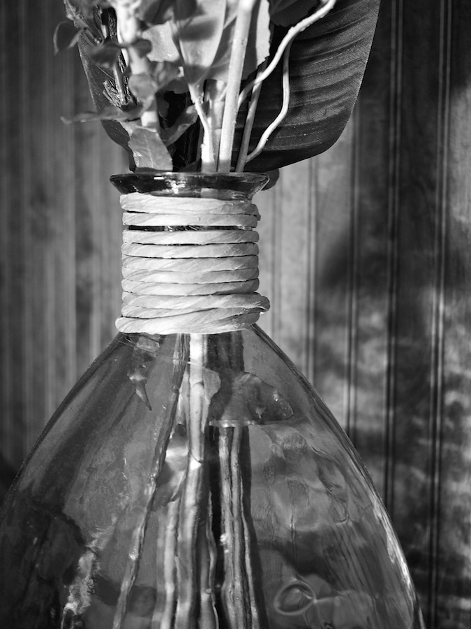 Glass vase with raffia.