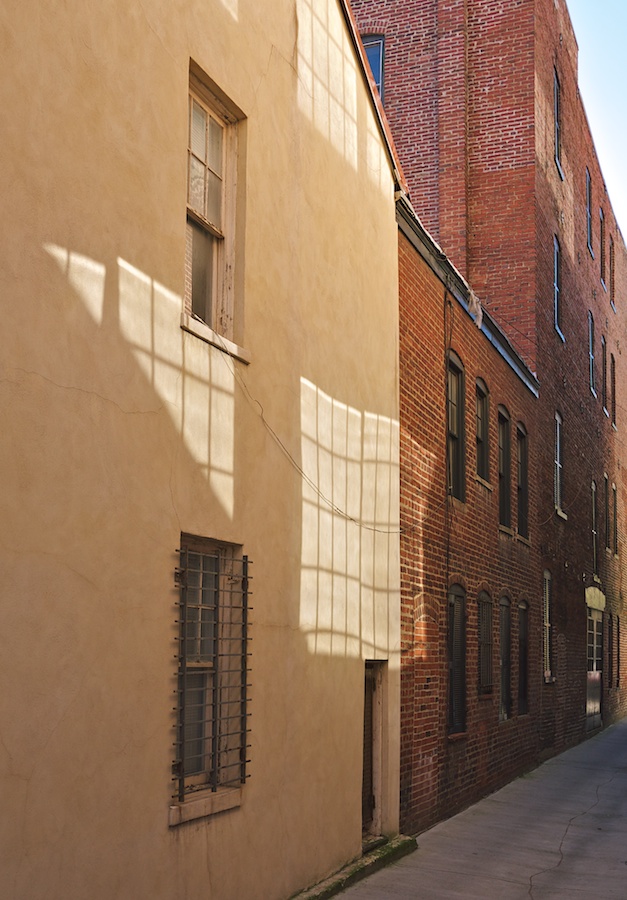 Windows and window reflections in alleyway.