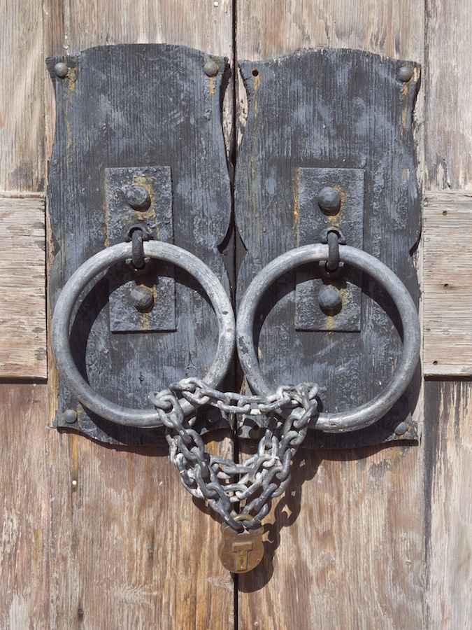 Old door knobs and locked chain.