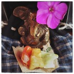 Little Ganesha with flower and food offerings.