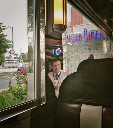 Man reflected in metal surface at diner.